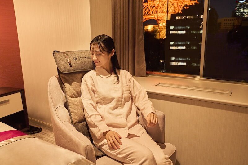 好きな体勢でコリをほぐせる「3Dマッサージシートflatty」に座る人の写真