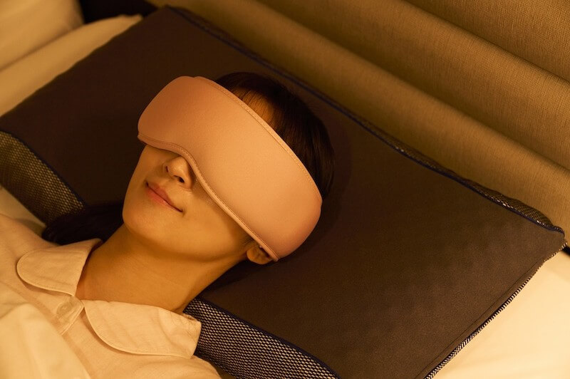 温感と振動でやさしくケアしてくれる「ホット＆ウェーブアイマスク」を着用している人の写真