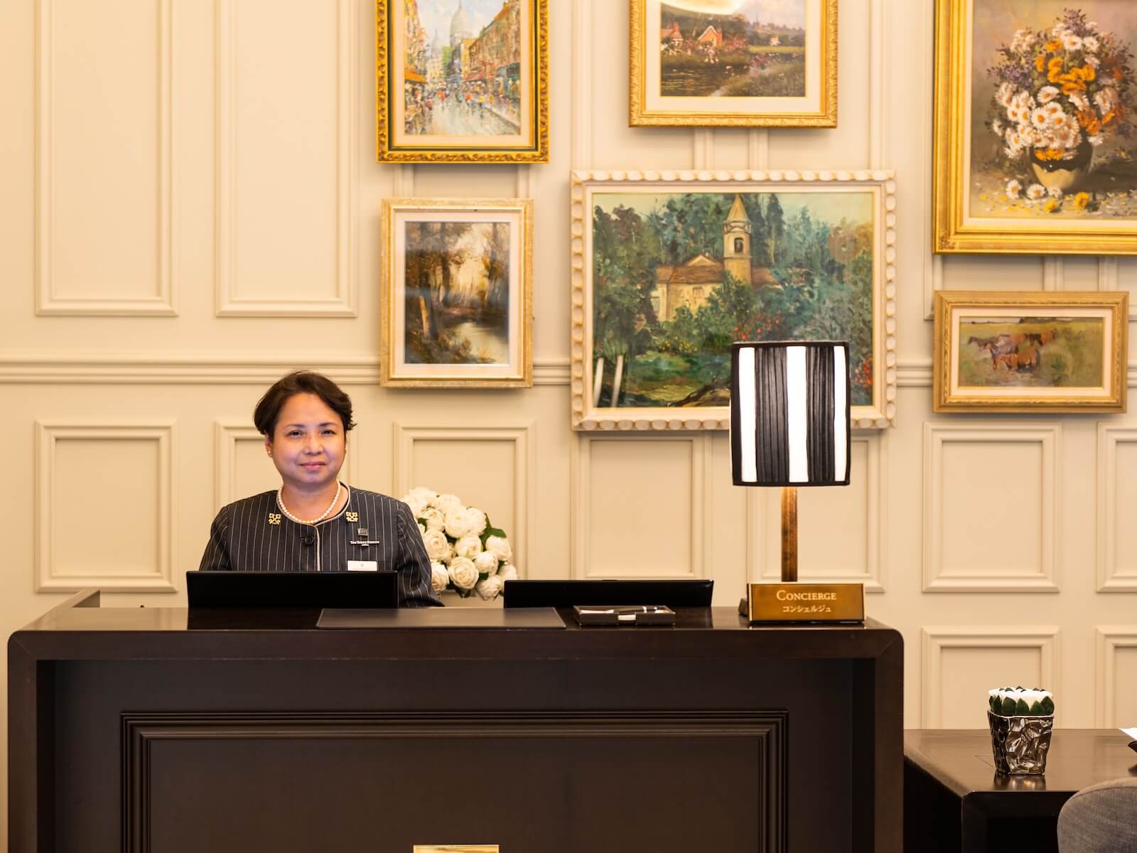 東京ステーションホテルのカウンターで来客を迎えるチーフコンシェルジュの森マリーアントワネットさんの写真