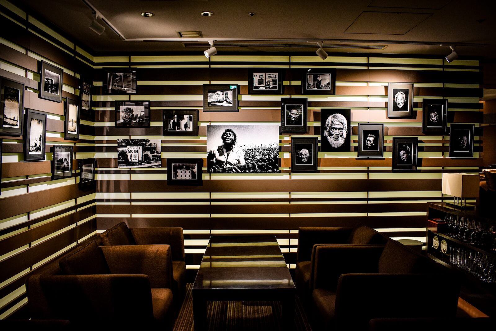 壁一面にモノクロ写真作品が展示された空間。写真家・長濱治氏の代表作がずらりと並び、ラウンジ席から鑑賞できる展示コーナー