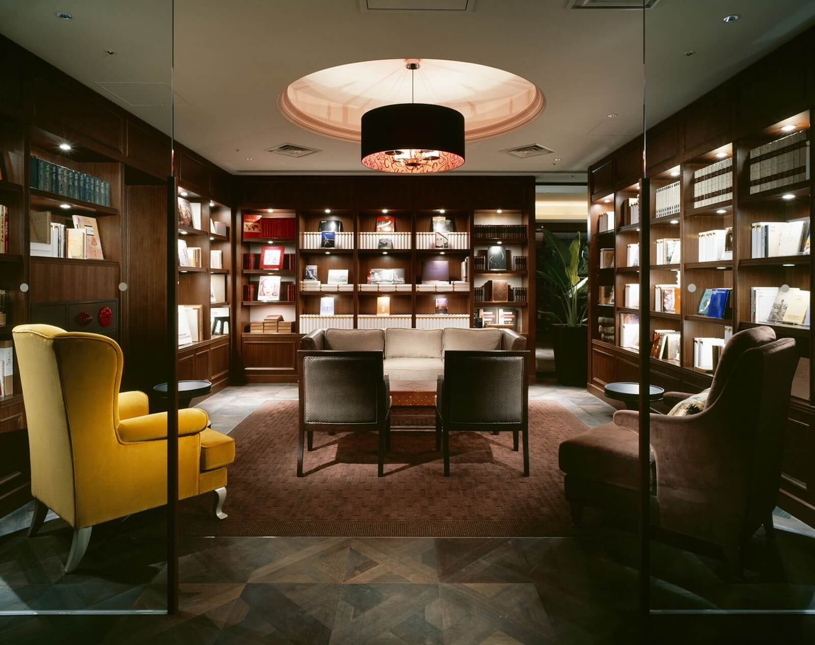 『ある文化人の書斎』をテーマに設えられたホテル内ライブラリー。木製書棚に本が整然と並び、ソファやアームチェアが配置された落ち着いた空間