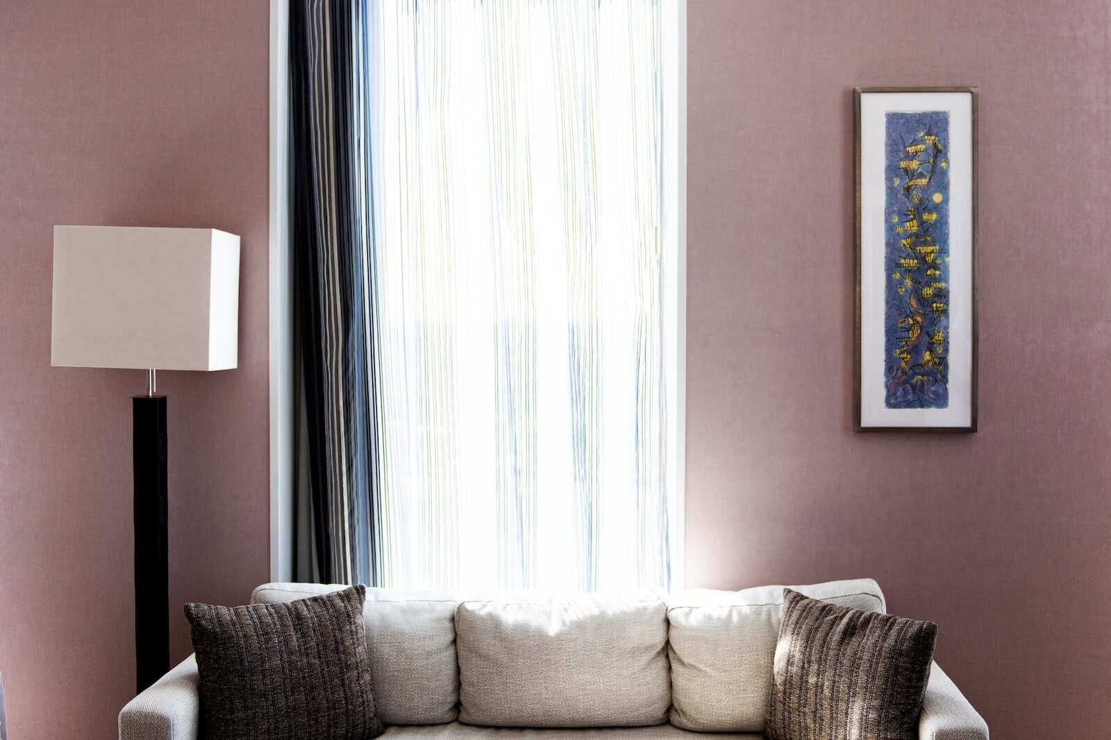 客室リビングの壁に、アーティスト提供の縦長作品が一点展示された空間。