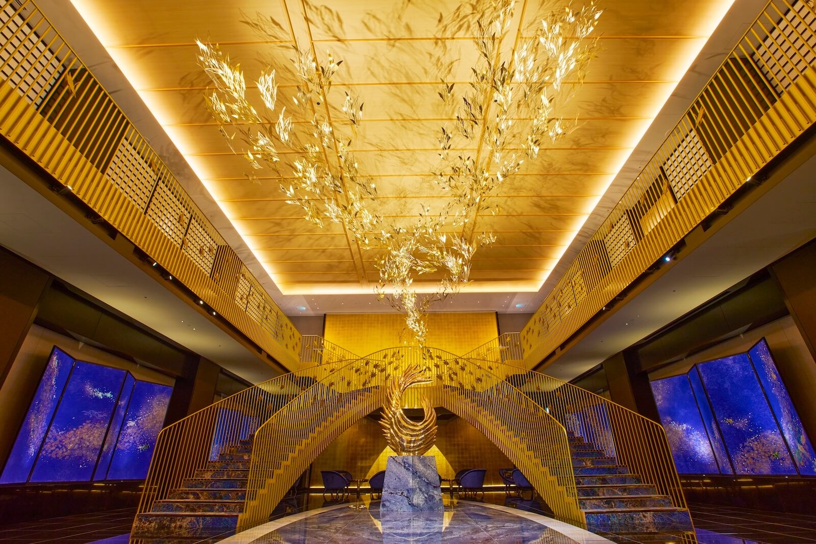 宿泊者専用エントランスの先に広がる、金色の天井装飾と立体作品が象徴的な「鳳凰階段」