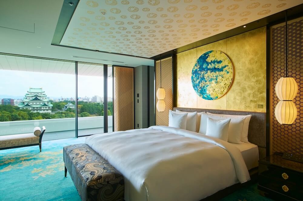 壁面に円形のアート作品を配した客室のベッドルーム