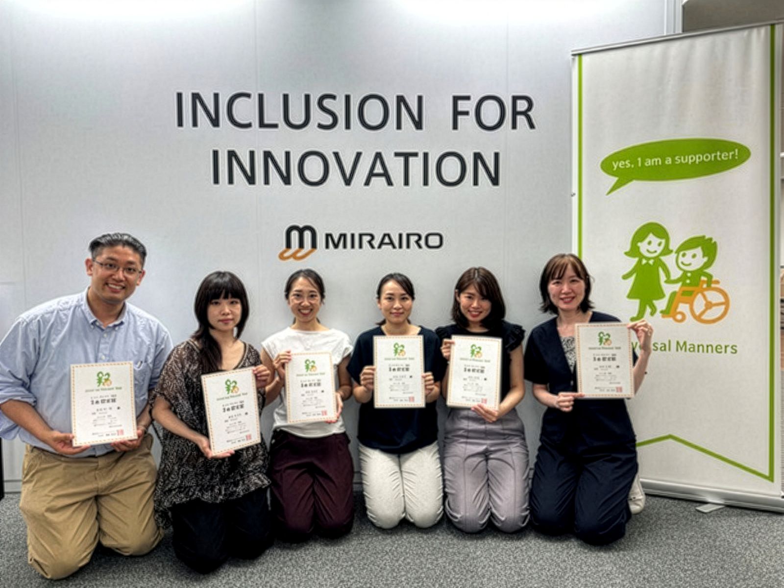 「INCLUSION FOR INNOVATION」「MIRAIRO」のロゴを背景に、修了証を手にした参加者が並んで記念撮影している様子。