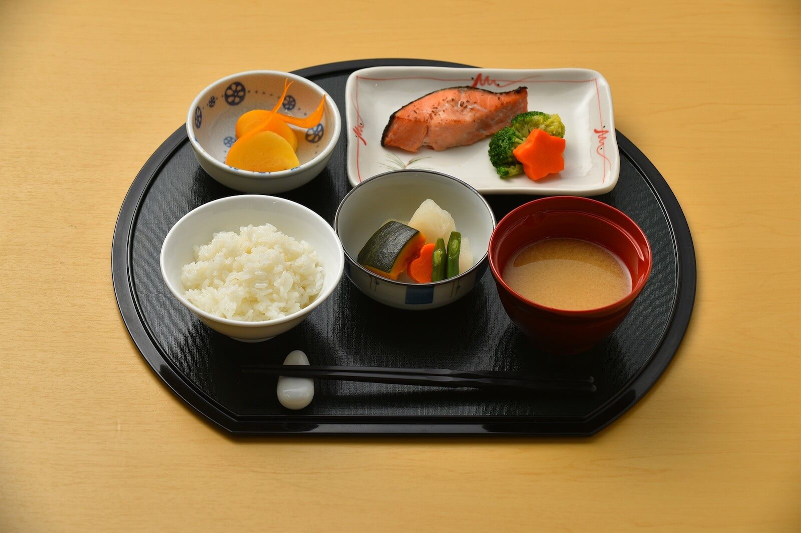 ご飯、焼き魚、煮物、味噌汁などが並んだ和定食のトレー。