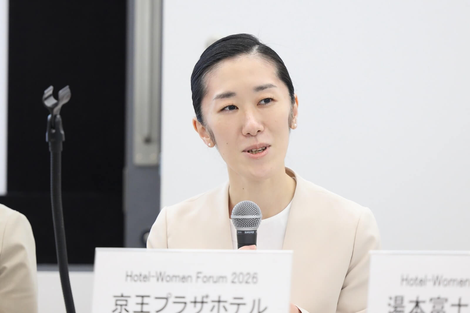 京王プラザホテル 料飲宴会部 宴会サービス副支配人 武井真理子さんがマイクの前で登壇している様子