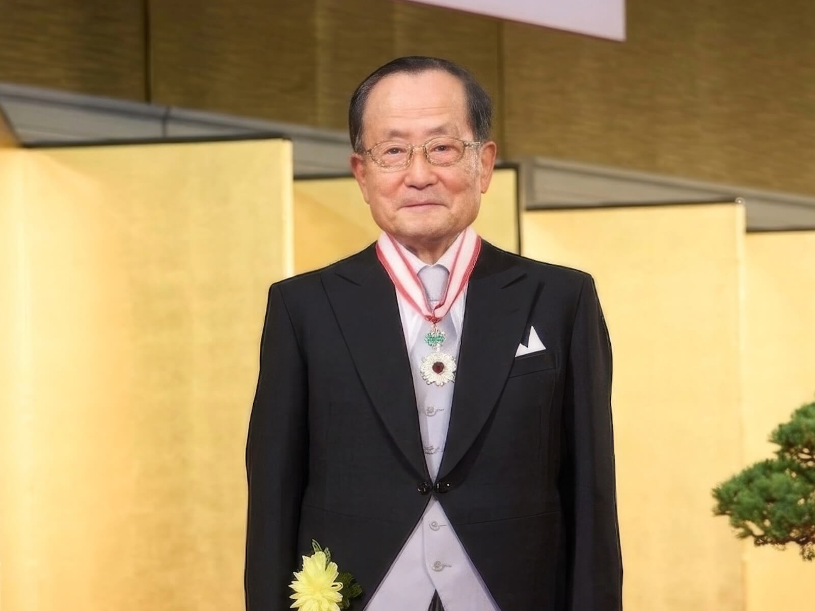 小林節氏の肖像。勲章を胸に着け、金屏風を背景にタキシード姿で正面を向いて立っている。
