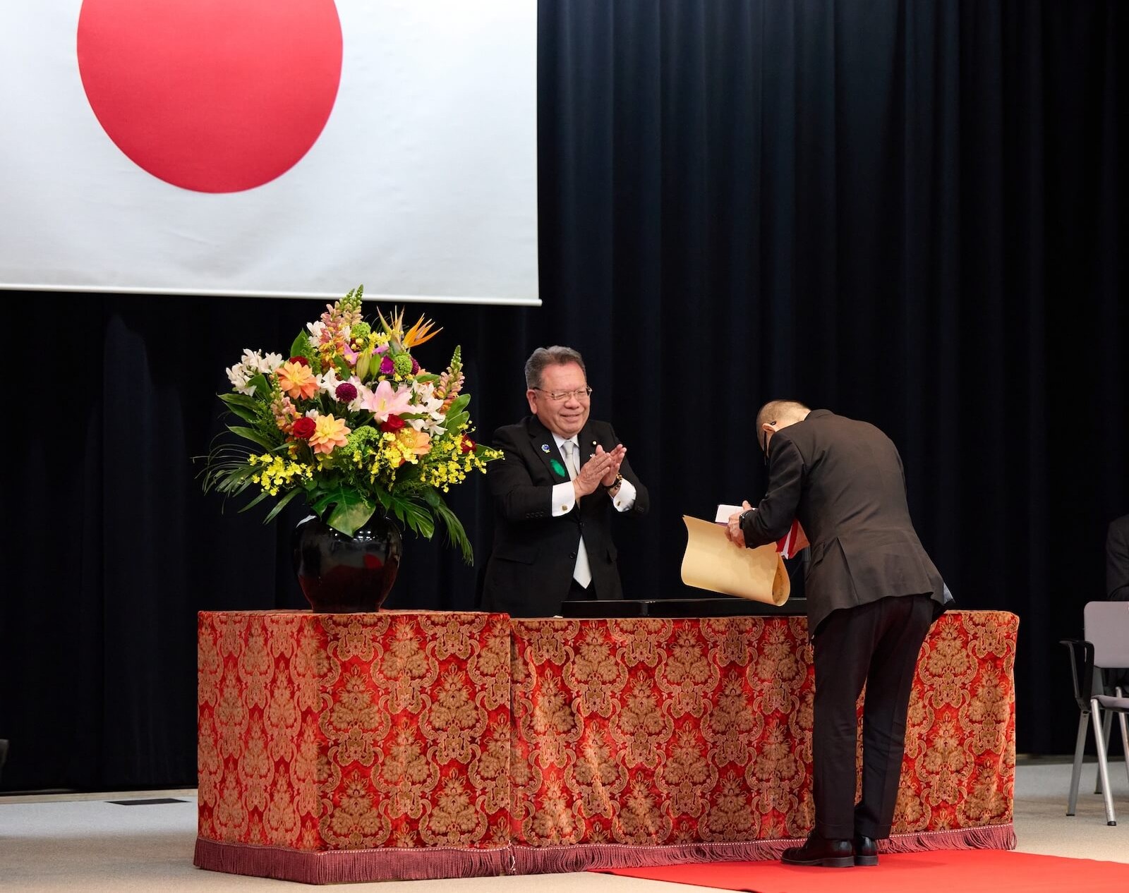 受章者が酒井庸行国土交通副大臣から表彰状を受け取り、拍手で祝福されている様子。