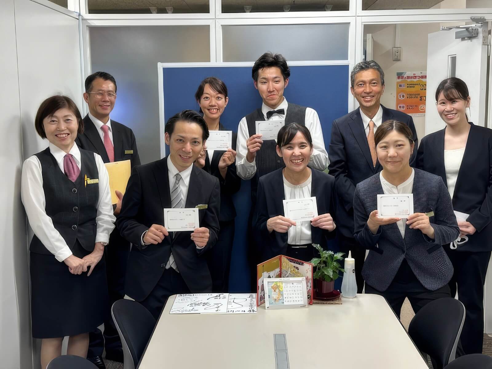 賞状を手に笑顔で記念撮影するホテルスタッフたち。
